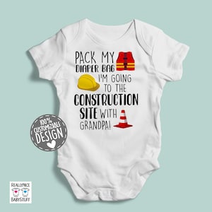 May include: White baby onesie with black text that reads "Pack my diaper bag I'm going to the construction site with grandpa!"  The onesie has a yellow hard hat, a red and orange traffic cone, and a red life vest.