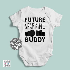 May include: White baby bodysuit with black text that reads "Future Sparring Buddy" and two black boxing gloves. The text "100% Customizable Design" is in a heart-shaped box.