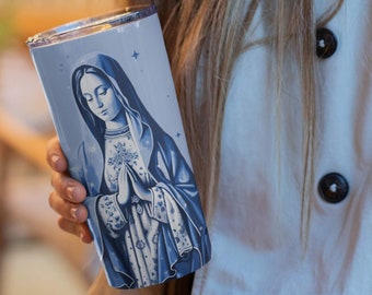 May include: A stainless steel tumbler with a blue and white image of the Virgin Mary. The image is surrounded by a white background with blue stars.
