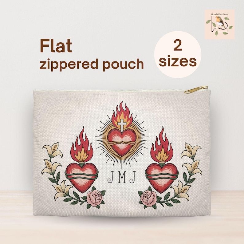 May include: A flat, zippered pouch with a gold zipper. The pouch features a central heart design with flames, a cross, and the initials "JMJ". Floral and rose accents surround the heart. The text "Flat zippered pouch" and "2 sizes" are also visible.