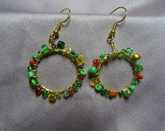 May include: Gold hoop earrings with green, red and yellow beads.