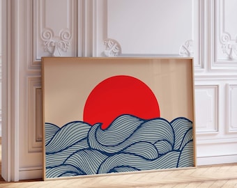 Puede incluir: Una impresión enmarcada de un sol rojo estilizado poniéndose sobre olas azules y blancas. La impresión está en un marco de madera claro y está colgada en una pared blanca.