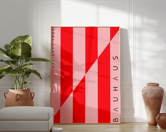 May include: A framed poster with a red and pink striped design. The poster has the text "BAUHAUS" and "JULI - SEPT 1923" printed on it.