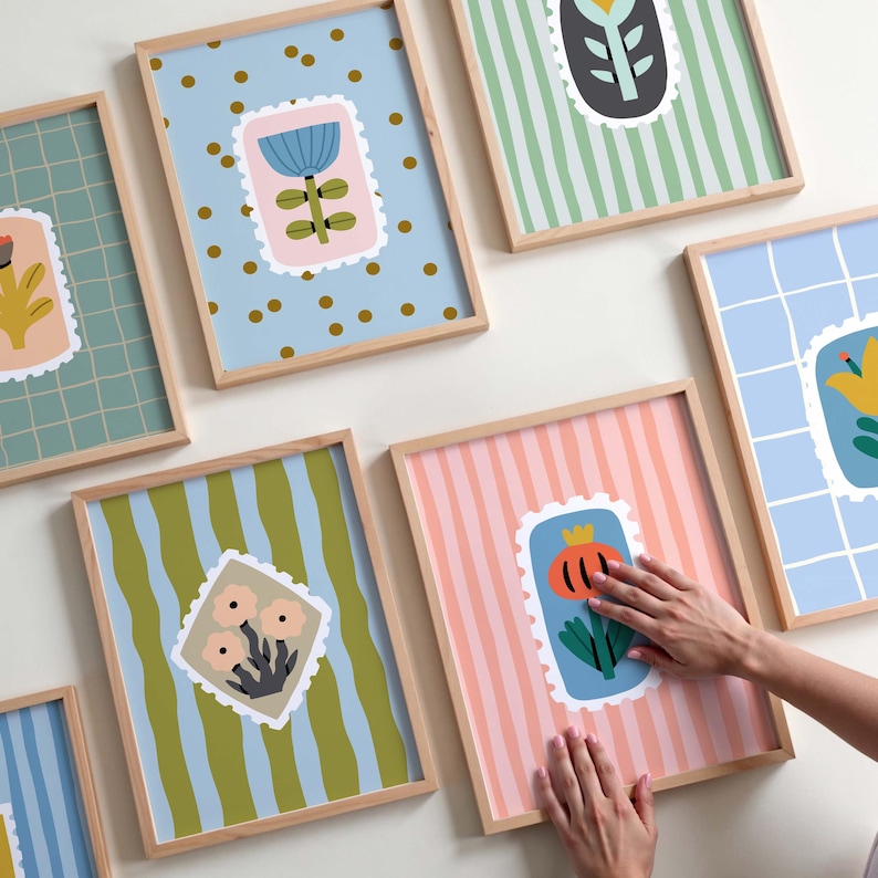 Puede incluir: Una colecci&oacute;n de l&aacute;minas art&iacute;sticas enmarcadas con dise&ntilde;os florales. Cada l&aacute;mina presenta una colorida ilustraci&oacute;n floral dentro de un borde similar a un sello postal. Los fondos var&iacute;an con patrones como rayas, puntos y cuadr&iacute;culas. Los marcos son de madera clara.