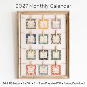 May include: A 2027 monthly calendar displayed in a wooden frame with twelve square cards clipped to twine. Each card features a unique floral pattern and month name. Text includes 2027 Monthly Calendar, A4 & US Letter, 5 x 5 in, 3 x 3 in.