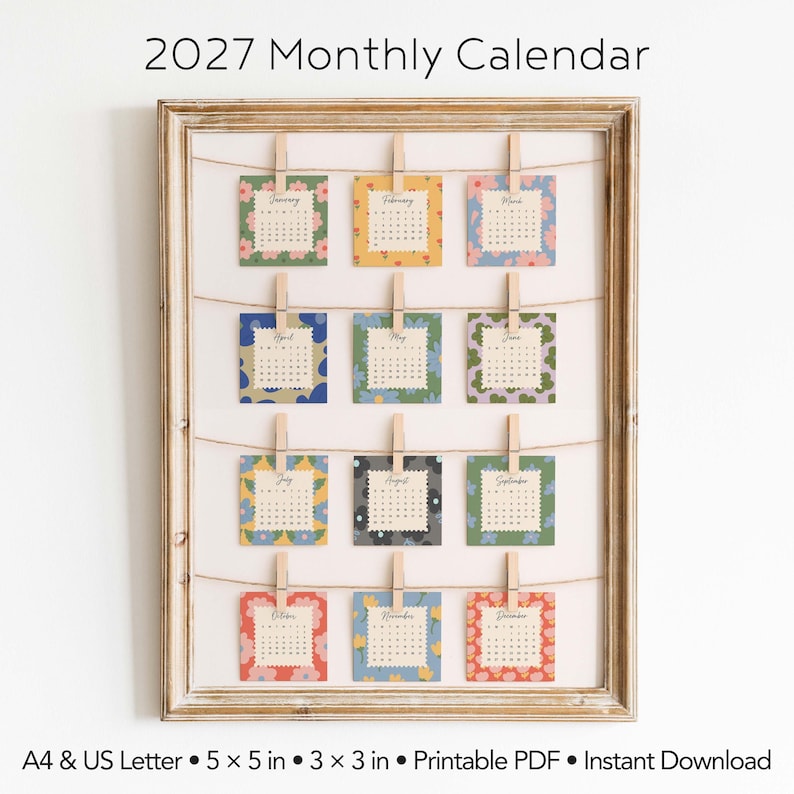 May include: A 2027 monthly calendar displayed in a wooden frame with twelve square cards clipped to twine. Each card features a unique floral pattern and month name. Text includes 2027 Monthly Calendar, A4 & US Letter, 5 x 5 in, 3 x 3 in.