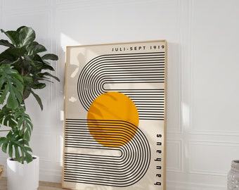 May include: A minimalist poster with a black and white geometric design featuring a large yellow circle. The text "JULI. SEPT 1919" and "bauhaus" are printed on the poster.