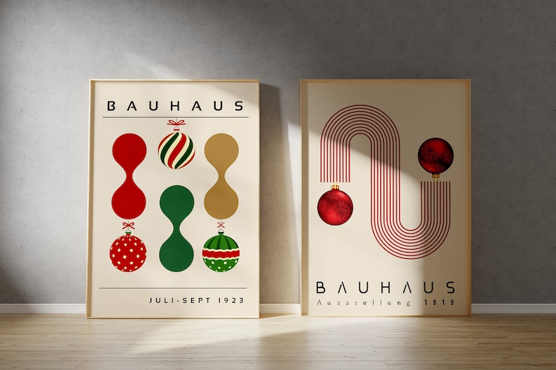 May include: Two framed posters with cream backgrounds. The left poster features the text BAUHAUS and JULI-SEPT 1923 with red, green, and gold ornaments. The right poster features the text BAUHAUS and Ausstellung 1919 with red lines and ornaments.