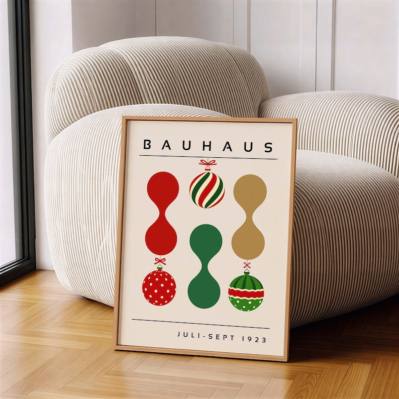 May include: A framed poster with a cream background featuring the text BAUHAUS at the top and JULI-SEPT 1923 at the bottom. The design includes three vertical columns of abstract shapes and Christmas ornaments in red, green, and gold colors.