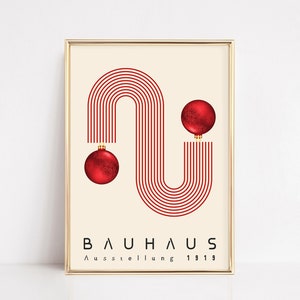 May include: A framed poster featuring a cream background with a red graphic of parallel lines forming an S-shape. Two red spherical ornaments are attached to the ends of the lines. The text BAUHAUS Ausstellung 1919 is printed in black at the bottom.