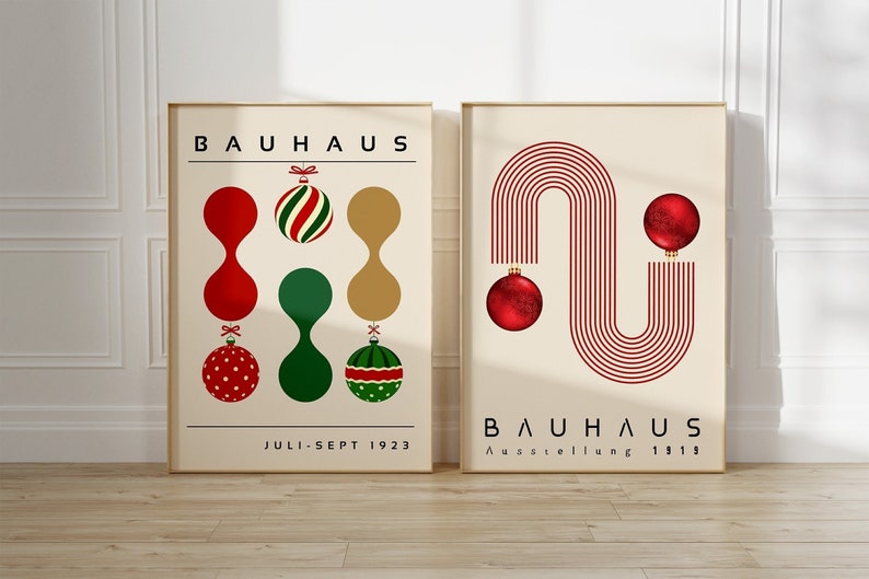 May include: Two framed posters with cream backgrounds. The left poster features the text BAUHAUS and JULI-SEPT 1923 with red, green, and gold ornaments. The right poster features BAUHAUS Ausstellung 1919 with red line art and two red ornaments.