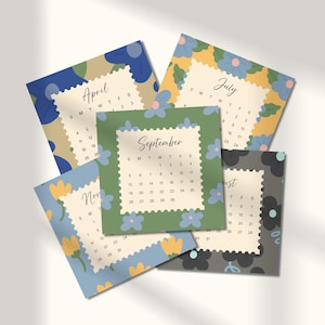 May include: A collection of five square calendar cards featuring months April, July, September, November, and August. Each card has a scalloped-edge center with dates and floral patterns in blue, green, yellow, and gray on the borders.