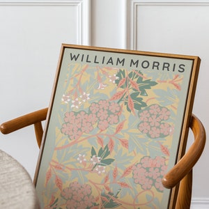 May include: A framed print of a floral design by William Morris, titled "Jasmine, 1872". The print features a yellow background with pink and green flowers and leaves. The print is from the Met Museum.