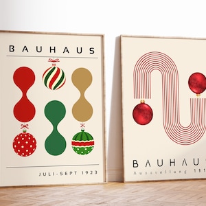 May include: Two framed posters with cream backgrounds. The left poster features the text BAUHAUS, JULI-SEPT 1923, and colorful ornaments. The right poster displays BAUHAUS, Ausstellung 1919, red line patterns, and two red spherical ornaments.