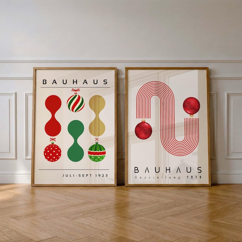 May include: Two framed posters with cream backgrounds. The left poster features the text BAUHAUS, JULI-SEPT 1923, and abstract shapes with red, green, and gold Christmas ornaments. The right poster displays BAUHAUS, Ausstellung 1919, and red lines.