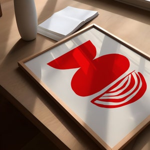 May include: A framed print with a red abstract design of a half-circle and a curved shape. The design is on a white background.
