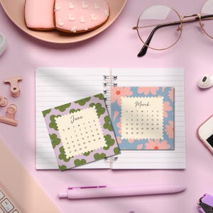 May include: A spiral-bound notebook featuring two square calendar pages for June and March. The June page has a green clover pattern, while the March page displays a blue background with pink flowers. Both pages have scalloped edges.