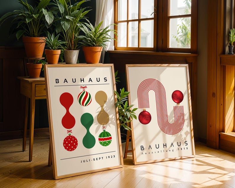 May include: Two framed posters with light backgrounds and wooden frames. The left poster features the text BAUHAUS, JULI-SEPT 1923, and abstract shapes with Christmas ornaments. The right poster displays BAUHAUS, Ausstellung 1923, and red line art.
