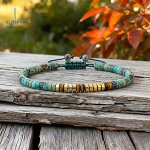 Op de afbeelding: Een turquoise en gouden kralenarmband met een macramé sluiting. De armband heeft turquoise gekleurde kralen en goudkleurige kralen. De armband wordt gepresenteerd op een houten oppervlak. De tekst "LIZ CREATION" is zichtbaar in de linkerbovenhoek.