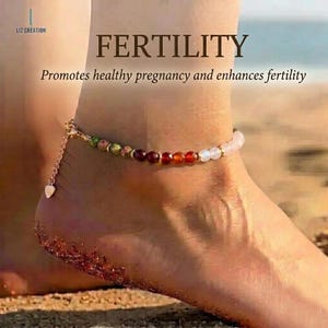 Può includere: Cavigliera con perline di pietre preziose colorate, tra cui verde, rosso e bianco, infilate su una catena d'oro. La cavigliera è indossata su una caviglia su una spiaggia sabbiosa. Il testo recita "FERTILITY" e "Promuove una gravidanza sana e aumenta la fertilità."