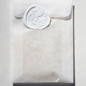 May include: A white envelope with a wax seal that says "With Love" in cursive.