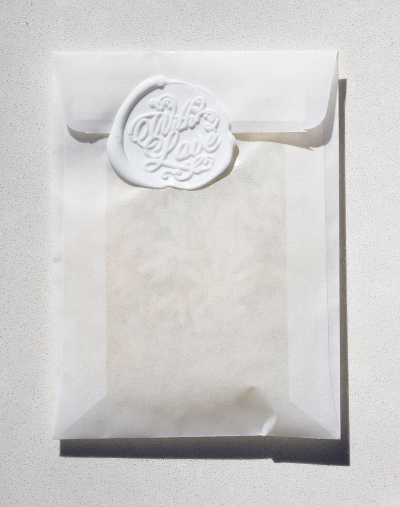 May include: A white envelope with a wax seal that says "With Love" in cursive.