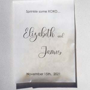 May include: White paper bag with the text "Sprinkle some XOXO..."  "Elizabeth and James"  "November 15th, 2021"