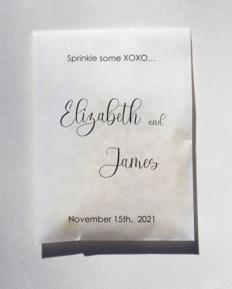 May include: White paper bag with the text "Sprinkle some XOXO..."  "Elizabeth and James"  "November 15th, 2021"