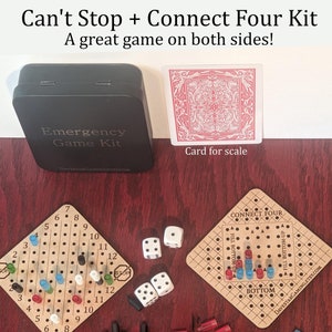 May include: A wooden game board with a Connect Four game on one side and a Can't Stop game on the other side. The game board is brown with white markings. There are red, blue, and black game pieces on the board. There are also four white dice on the table.