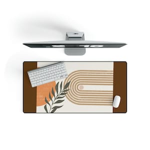 May include: A brown and white desk mat with a geometric design featuring a rainbow arch and a sun. The mat also has a green leaf design and a white computer keyboard.