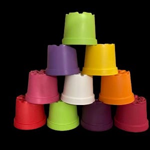 Op de afbeelding: Een set van negen kleurrijke plastic potten, gerangschikt in een piramidevorm. De potten zijn in verschillende tinten groen, paars, roze, wit, oranje en rood.