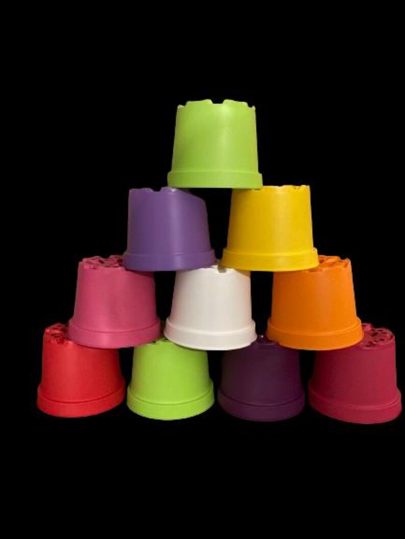Op de afbeelding: Een set van negen kleurrijke plastic potten, gerangschikt in een piramidevorm. De potten zijn in verschillende tinten groen, paars, roze, wit, oranje en rood.