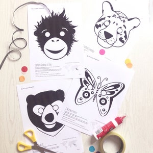 May include: Four printable animal masks, including an orangutan, a clouded leopard, a butterfly, and a bear. The masks are black and white and have cut-out eye holes. There are also colourful craft supplies, including glue, scissors, and confetti.