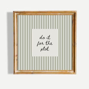 May include: A framed print with a gold-colored wooden frame. The artwork features a striped background in shades of green and white. A square in the center has the phrase "do it for the plot" in black script.