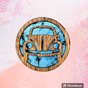 May include: A wooden round coaster with a blue silhouette of a classic Volkswagen Beetle.
