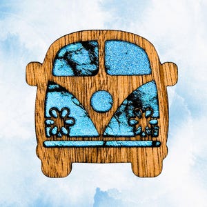 May include: A wooden cutout shaped like a van with a front-facing view. The design features a natural wood grain frame with bright blue, textured, glittery inlays in the windows and front panels, including two flower shapes on the lower sides.