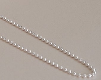 May include: A silver chain necklace with small round beads.