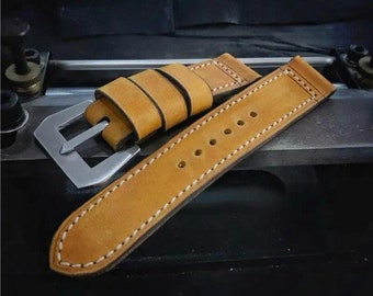 May include: A tan leather watch strap with white stitching and a stainless steel buckle.