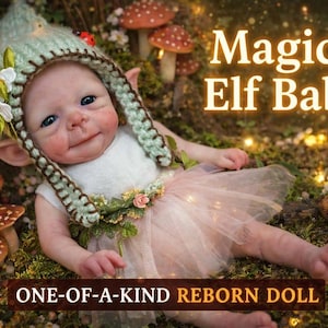 Może przedstawiać: Lalka reborn przebrana za elfa, w zielonym szydełkowym kapeluszu z uszami i różowym tutu. Lalka leży na mchu z grzybami i tekstem "Magical Elf Baby!" oraz "ONE-OF-A-KIND REBORN DOLL".
