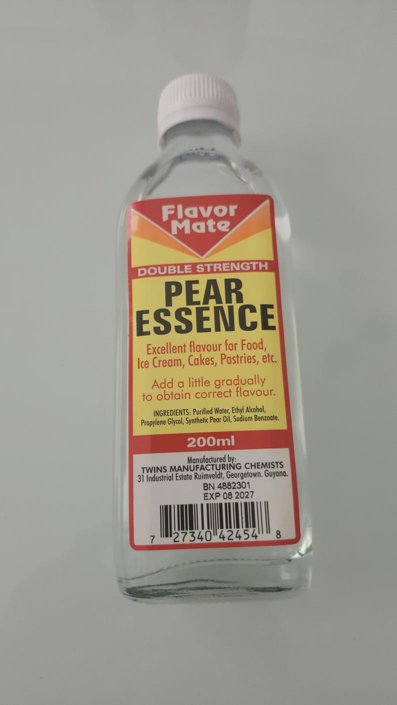 May include: A clear glass bottle of "Flavor Mate" Pear Essence, a food flavoring. The label is yellow and red with black text, including "Double Strength" and "200ml". The bottle has a white cap.