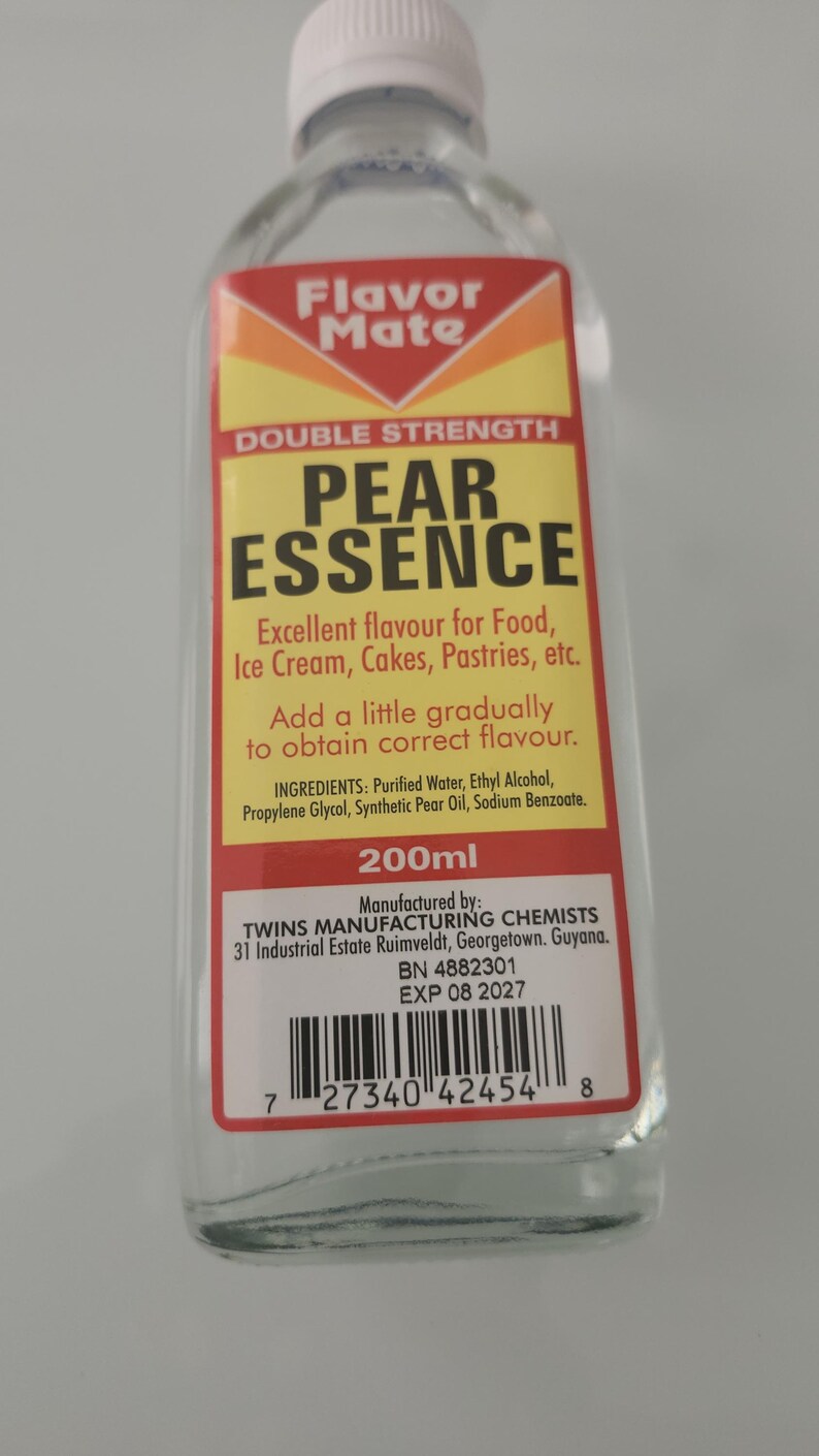 May include: A clear glass bottle of Flavor Mate Pear Essence. The label is yellow, red, and white, with text indicating it's double strength and for food flavoring. Contains 200ml.