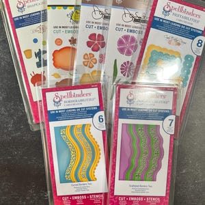 Könnte beinhalten: Ein Set mit sechs Spellbinders-Stanz- und Prägevorlagen zum Basteln. Die Vorlagen sind in Klarplastik verpackt und zeigen verschiedene Designs, darunter geschwungene Ränder, gewellte Ränder und Blumenformen. Die Verpackung enthält den Text "Spellbinders" und "Verwenden Sie in den meisten führenden Stanzsystemen".