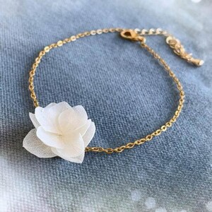 Bracelet de mariage fleur élégant et fait main, orné d’hortensias stabilisés blancs, un accessoire idéal pour les mariées.