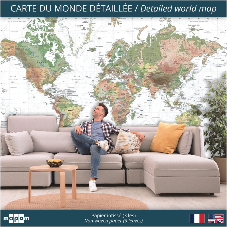 Pode incluir: Um mural de papel de parede com um mapa mundial detalhado em um ambiente de sala de estar. O mapa &eacute; impresso em papel n&atilde;o tecido e est&aacute; dispon&iacute;vel em tr&ecirc;s pain&eacute;is. O mapa apresenta uma combina&ccedil;&atilde;o de cores marrom claro e verde sobre um fundo branco. Uma pessoa est&aacute; sentada em um sof&aacute; seccional cinza claro em frente ao mapa.