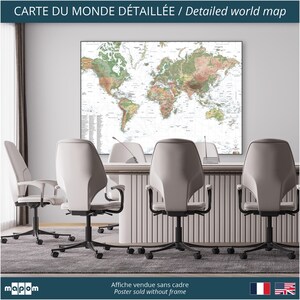 Pode incluir: Um p&ocirc;ster de mapa-m&uacute;ndi detalhado em uma moldura branca, pendurado em uma parede de uma sala de confer&ecirc;ncias. O mapa &eacute; impresso em tons de verde e marrom, com linhas brancas para as fronteiras e os rios. O p&ocirc;ster est&aacute; pendurado sobre uma mesa com quatro cadeiras de escrit&oacute;rio brancas.