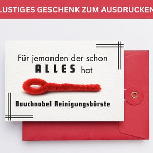 May include: A white card with the text "Für jemanden der schon ALLES hat" and "Bauchnabel Reinigungsbürste" is placed on a red envelope. A red pipe cleaner is on the card. The top of the image has the text "LUSTIGES GESCHENK ZUM AUSDRUCKEN".