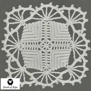 以下が含まれることがあります： 白く正方形のドイリーで、詳細な透かし彫りのデザインです。中央には幾何学模様があり、扇のような要素を持つスカラップエッジで囲まれています。ドイリーは灰色の背景に配置されています。「Pearls of Knits」のロゴが左下にあります。