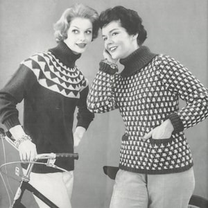 Puede incluir: Dos mujeres con suéteres de cuello alto con patrones geométricos. La mujer de la izquierda lleva un suéter con un patrón geométrico blanco y negro. La mujer de la derecha lleva un suéter con un patrón geométrico blanco y gris. Están de pie junto a una bicicleta.