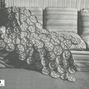 May include: A black and white crocheted throw blanket with a geometric pattern of hexagons. The blanket is draped over a striped couch.