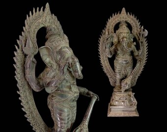 Op de afbeelding: Een bronzen beeld van de hindoeïstische godheid Ganesha, afgebeeld met een olifantenkop en vier armen. Het beeld is ingewikkeld gedetailleerd met sierlijke gravures en een halo-achtige structuur achter de godheid. Het beeld staat op een voetstuk met een decoratief ontwerp.